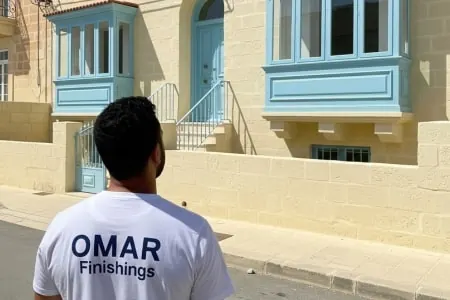 Professional plasterer inspecting paint work in Malta.